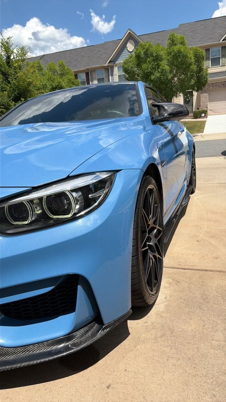 Front three-quarter of a Yas Marina Blue BMW M4 detailed to a mirror gloss